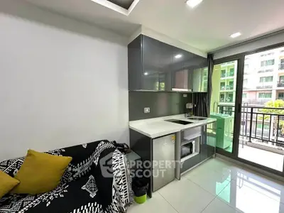 Modern kitchen with sleek cabinets and balcony view in urban apartment
