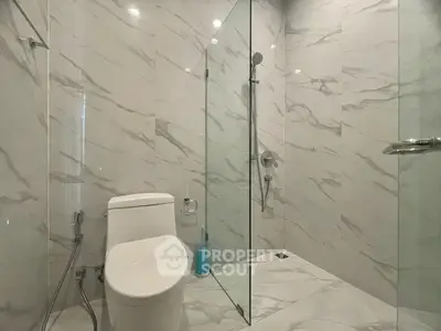 Modern bathroom with sleek glass shower and elegant marble tiles