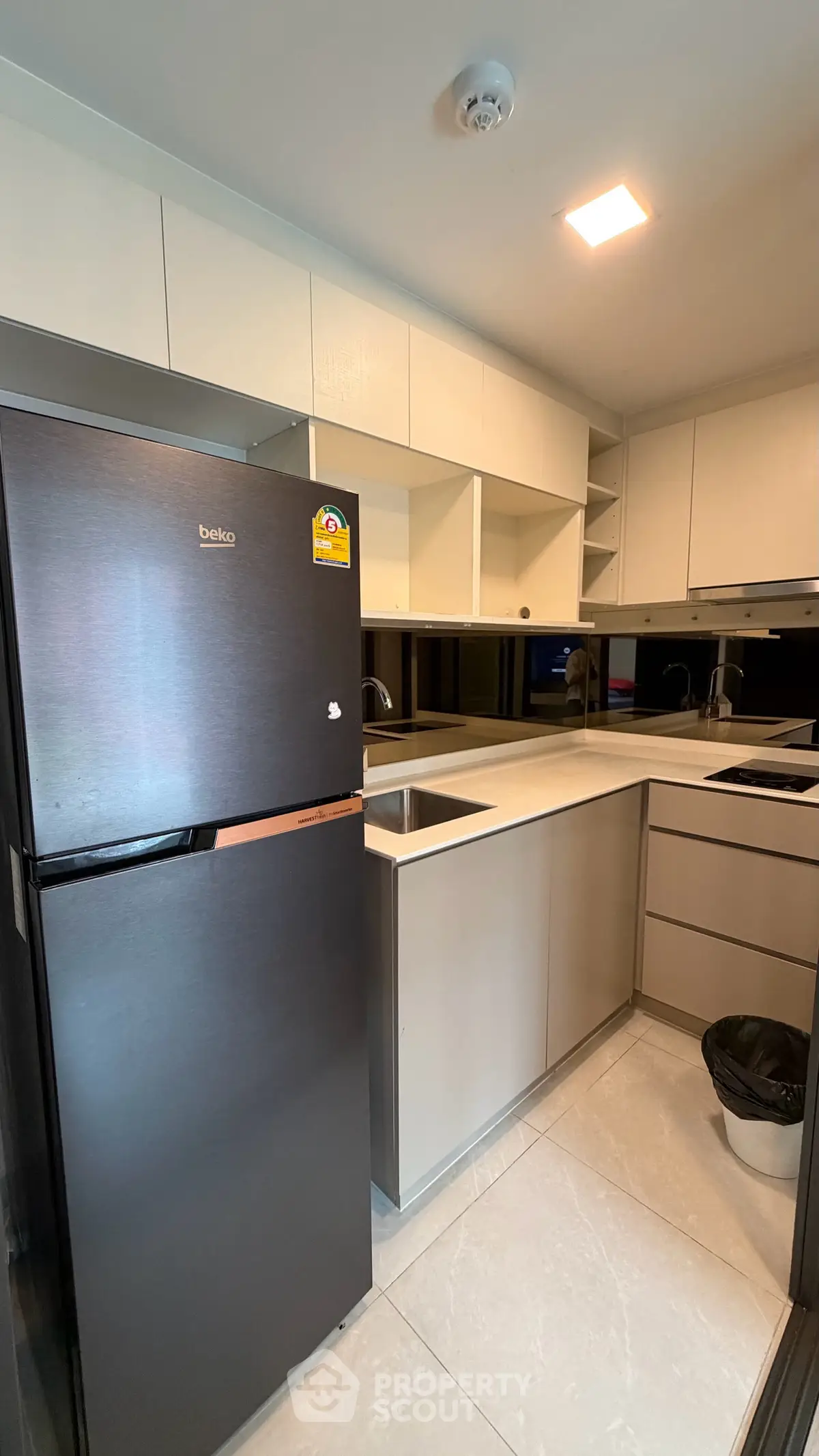 Modern kitchen with sleek cabinetry and stainless steel appliances in a contemporary apartment.