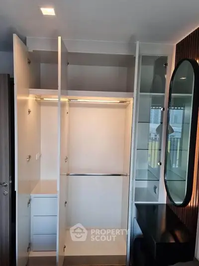 Spacious modern wardrobe with open doors and sleek design in a stylish bedroom setting.