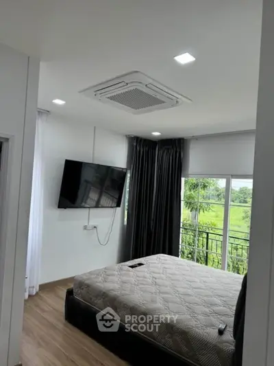 Modern bedroom with wall-mounted TV and scenic window view