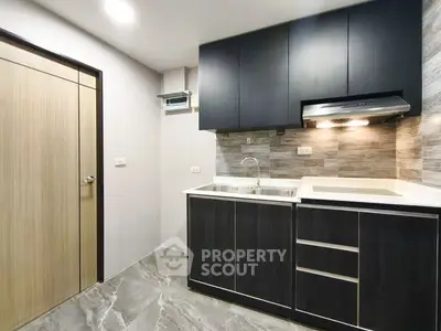 Modern kitchen with sleek cabinetry and stylish backsplash in a contemporary apartment.