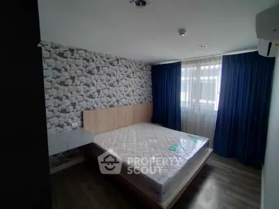 Modern bedroom with stylish wallpaper and large window with blue curtains.