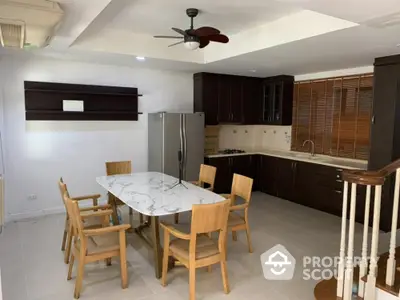 Spacious kitchen with modern dining area and wooden cabinetry