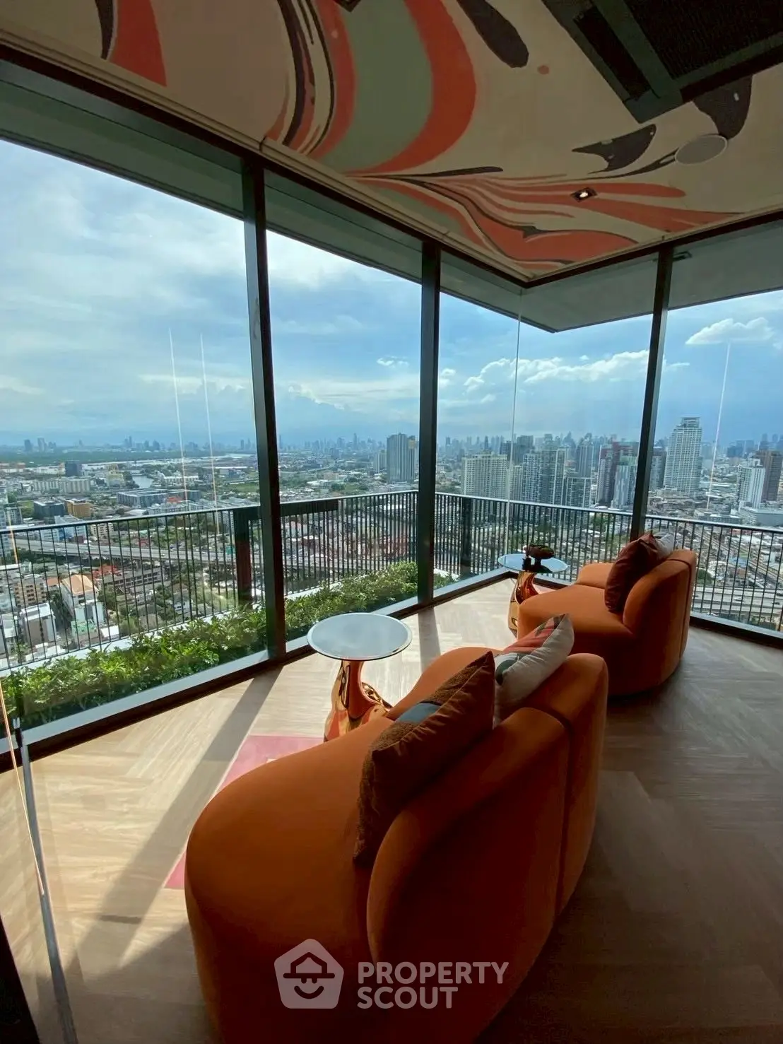 Luxurious living room with panoramic city view and stylish orange seating