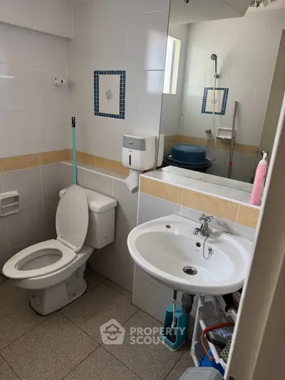 Modern bathroom with sleek fixtures and ample storage space, featuring a shower and contemporary design.