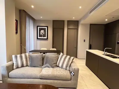 Modern living room with stylish sofa and open kitchen layout in luxury apartment.