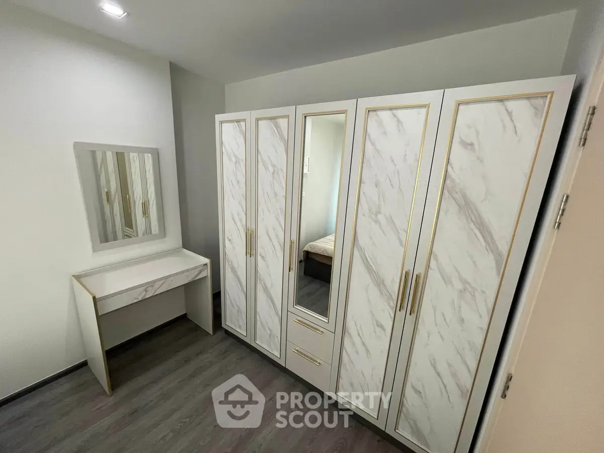 Elegant bedroom with stylish wardrobe and vanity set, featuring modern design and ample storage space.