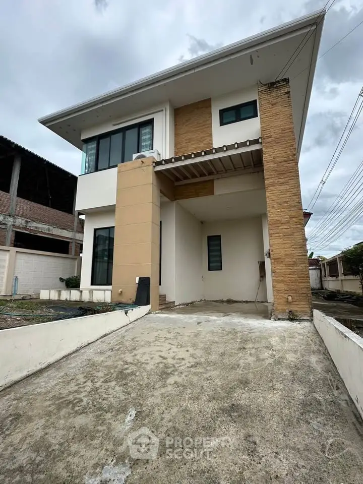 Modern two-story house with unique architectural design and spacious driveway.