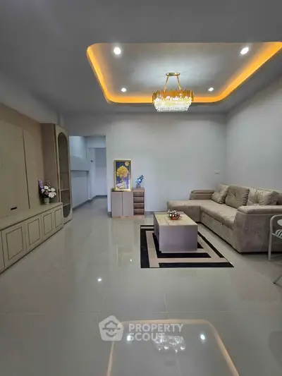 Elegant living room with modern chandelier and cozy sofa in a stylish apartment.