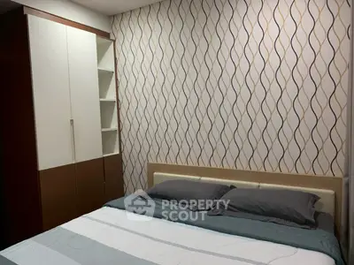 Modern bedroom with stylish wallpaper and built-in wardrobe