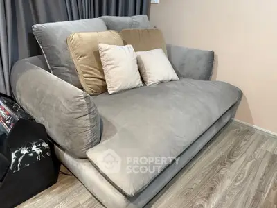 Cozy living room with plush gray sofa and stylish cushions, perfect for relaxation.