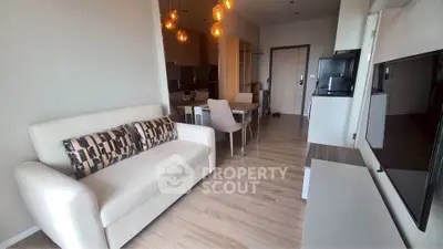 Modern living room with elegant decor and open kitchen layout in a stylish apartment.