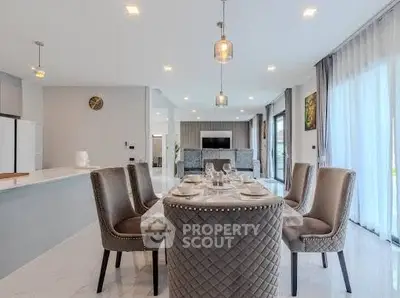 Luxurious open-plan living and dining area with elegant decor and modern lighting.