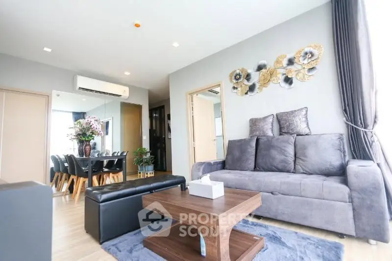 Modern living room with stylish decor and dining area in open layout apartment.