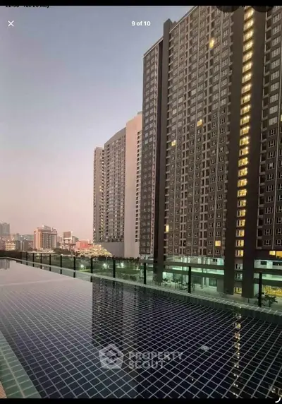 Stunning high-rise building with rooftop pool offering breathtaking city views at sunset.