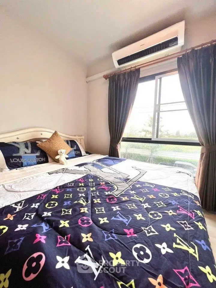 Stylish bedroom with luxury bedding and large window view.