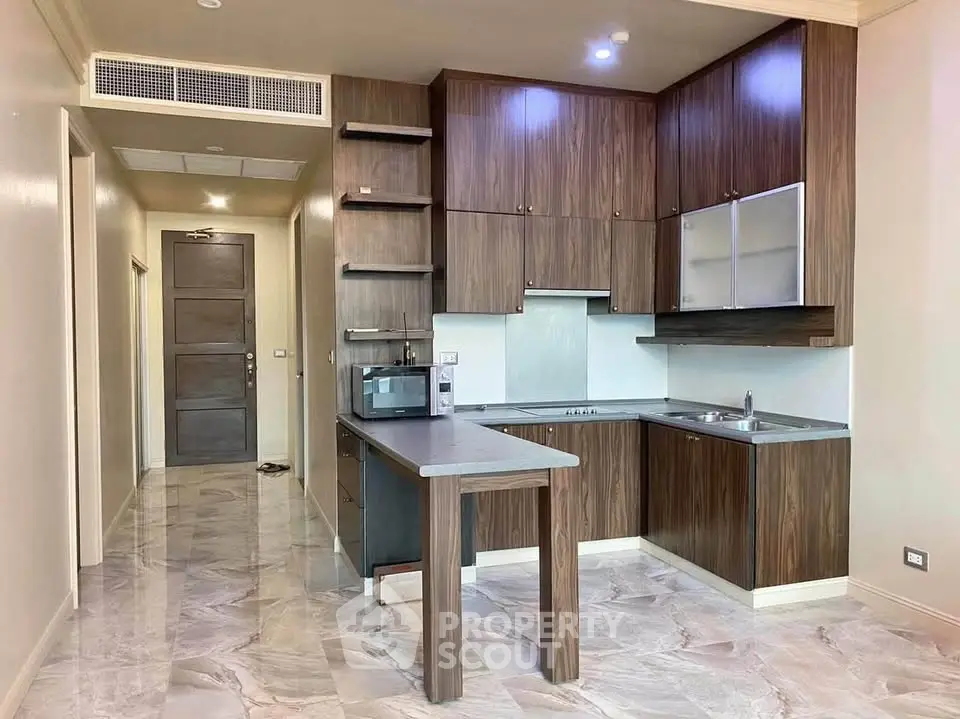 Modern kitchen with sleek wooden cabinets and marble flooring in a stylish apartment.