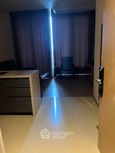Modern apartment entrance with sleek flooring and stylish furniture, featuring a cozy living area with natural light.