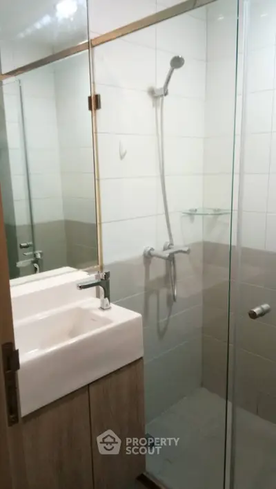 Modern bathroom with glass shower enclosure and sleek fixtures