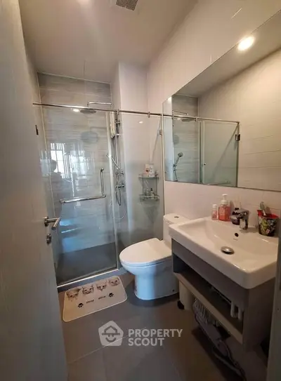 Modern bathroom with glass shower and sleek fixtures in a contemporary home.