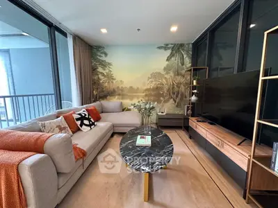 Stylish living room with modern decor and scenic wall mural, featuring a cozy sofa and sleek TV setup.