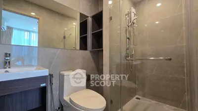 Modern bathroom with glass shower and sleek fixtures in a contemporary apartment.
