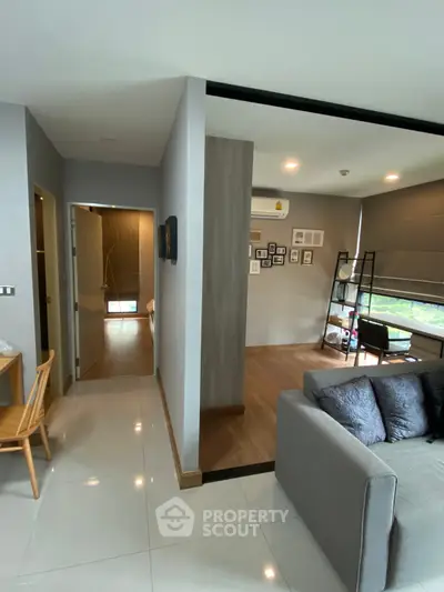 Modern living room with stylish decor and open layout, featuring a cozy sofa and wall art.