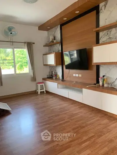 Spacious modern living room with wooden flooring and wall-mounted TV
