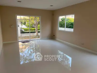 Spacious empty living room with large windows and glossy floors