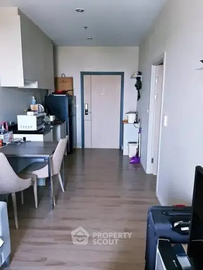 Modern apartment interior with open kitchen and dining area, featuring sleek appliances and stylish decor.