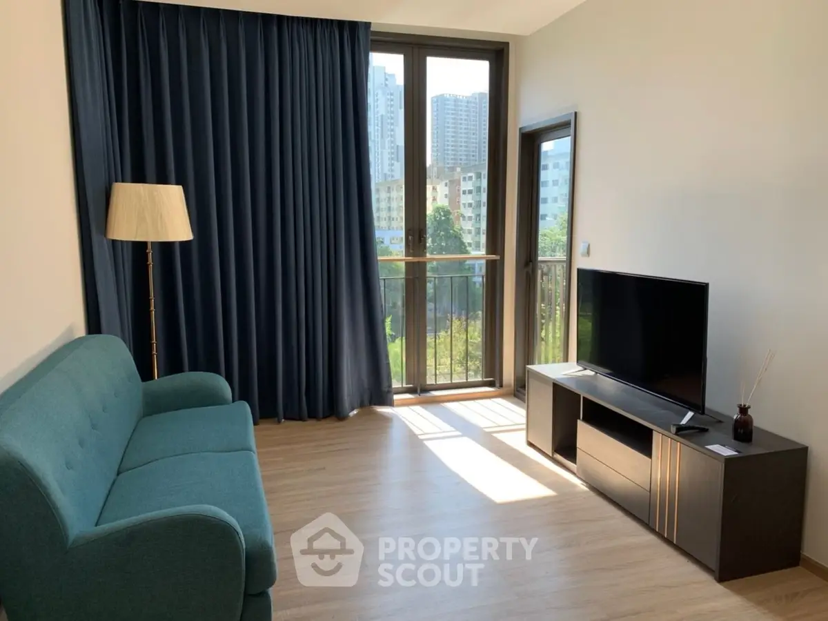 Modern living room with large window and city view, featuring a stylish sofa and flat-screen TV.