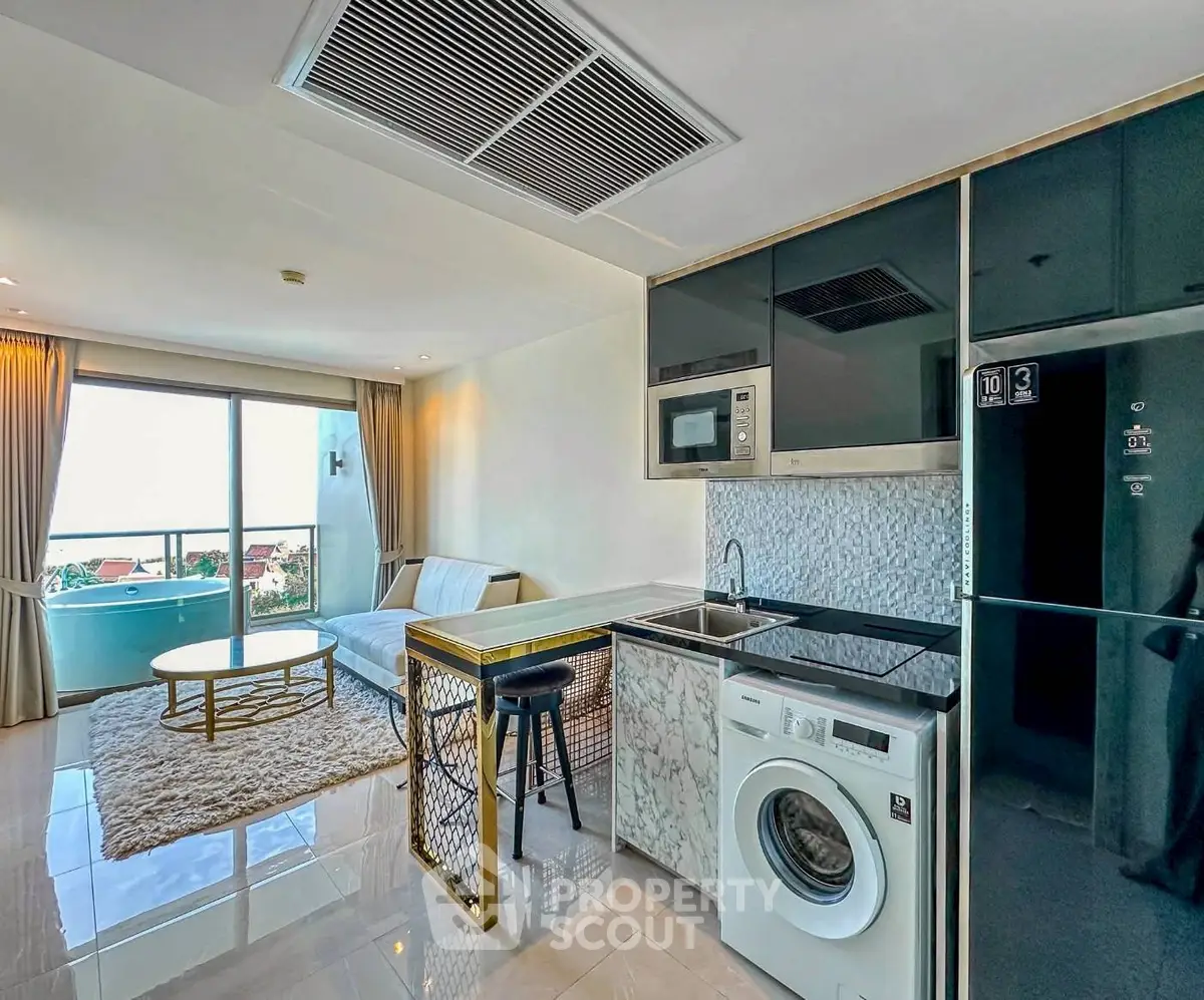 Modern open-plan living room with kitchen and balcony view