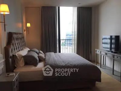 Luxurious bedroom with elegant decor and natural light, featuring a plush bed and modern TV setup.