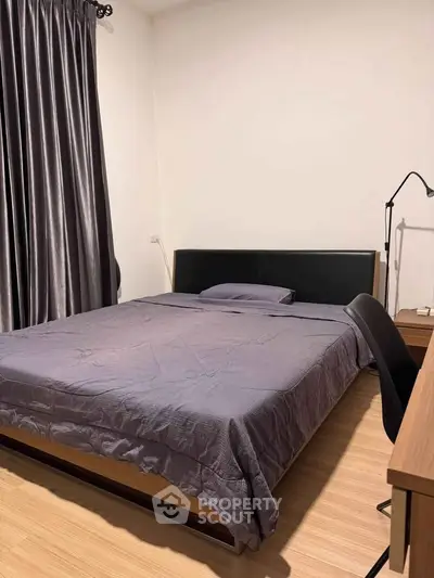 Cozy bedroom with modern furnishings and elegant curtains, perfect for relaxation.