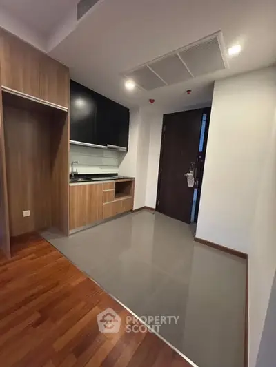 Modern kitchen with sleek cabinetry and wood flooring in a contemporary apartment.
