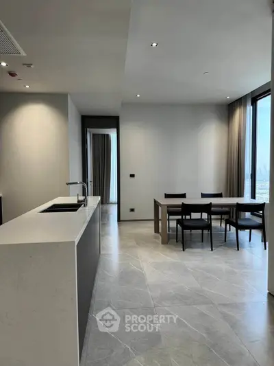 Modern open-plan kitchen and dining area with sleek design and city view.