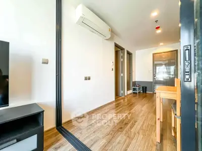 Modern apartment interior with wooden flooring and air conditioning, featuring a sleek open layout.