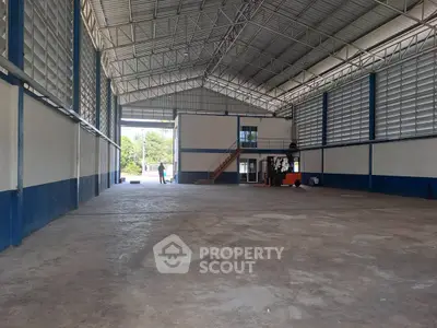 Spacious industrial warehouse with high ceilings and ample natural light.