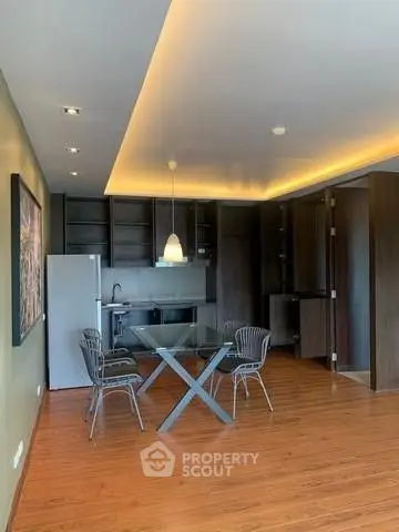 Modern kitchen with sleek design and dining area in open layout apartment.