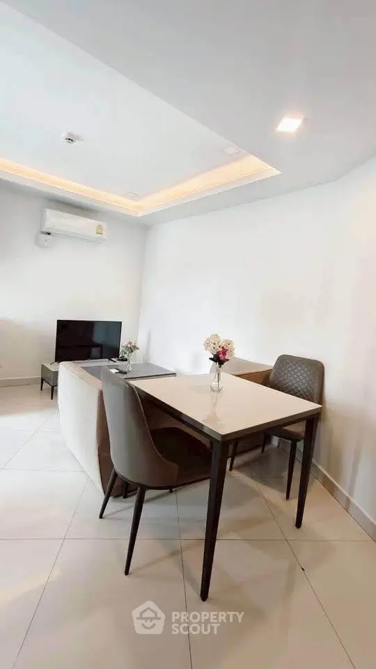 Modern living room with sleek furniture and minimalist design, featuring a cozy dining area and stylish decor.