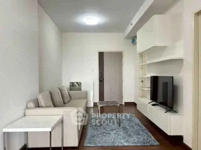 Modern living room with sleek furniture and mounted TV in a stylish apartment.