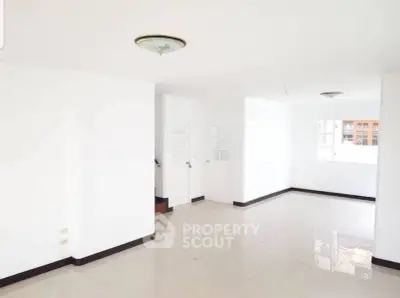 Spacious empty living room with white walls and tiled floor, ready for customization.