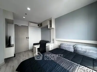 Modern bedroom with sleek design, featuring a cozy bed, desk, and TV, perfect for urban living.