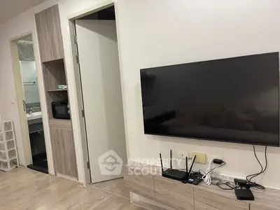 Modern living room with sleek TV setup and open bathroom view, showcasing contemporary design.