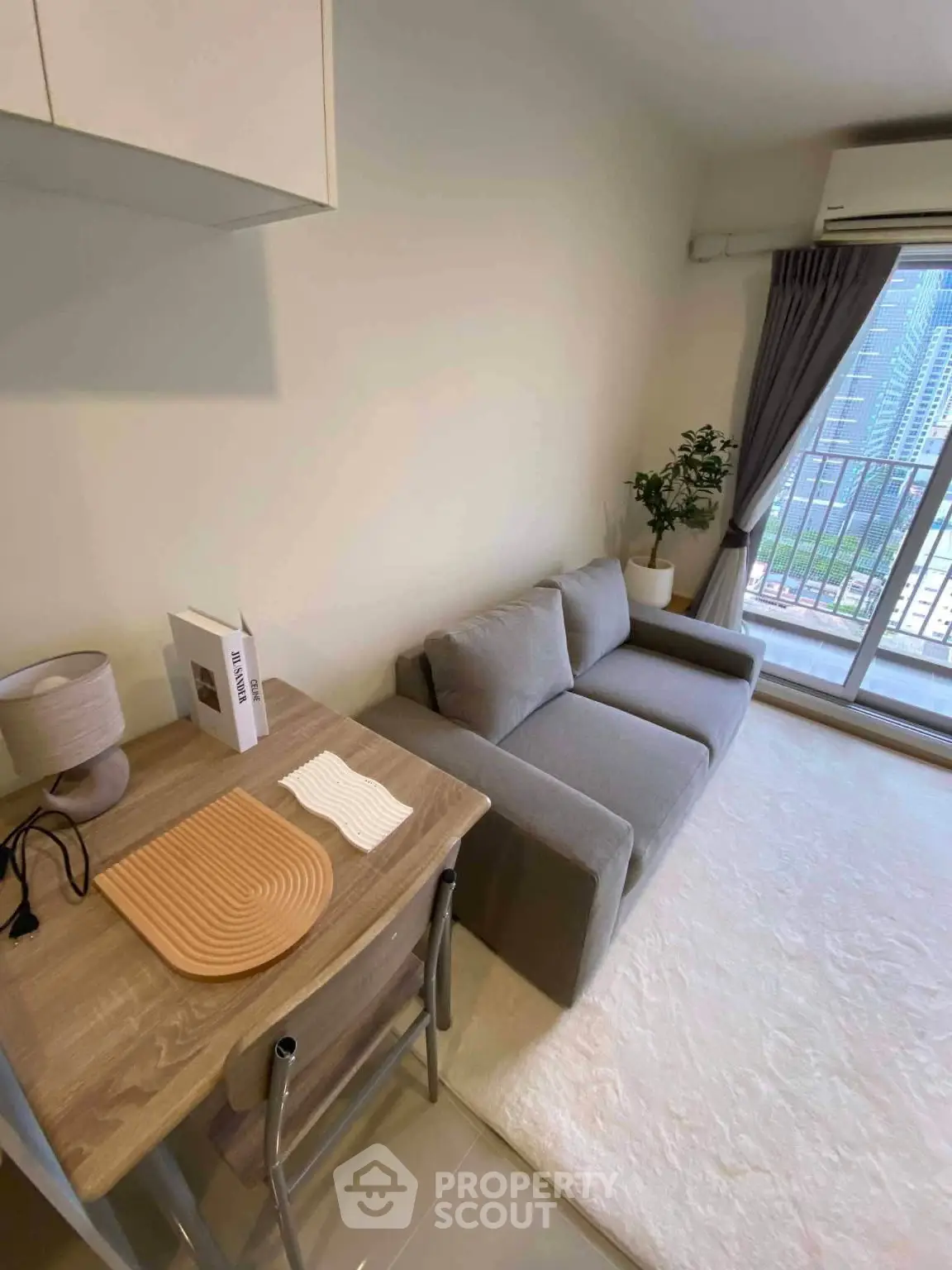 Modern living room with cozy gray sofa and balcony view in a stylish apartment.