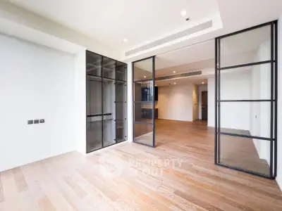 Spacious modern living room with glass partitions and wooden flooring