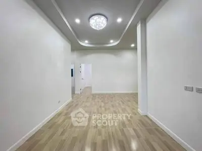 Spacious modern room with elegant ceiling lights and wooden flooring