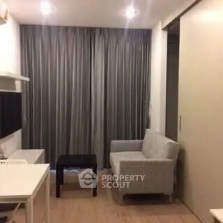 Cozy living room with modern furniture and floor-to-ceiling curtains in a stylish apartment.