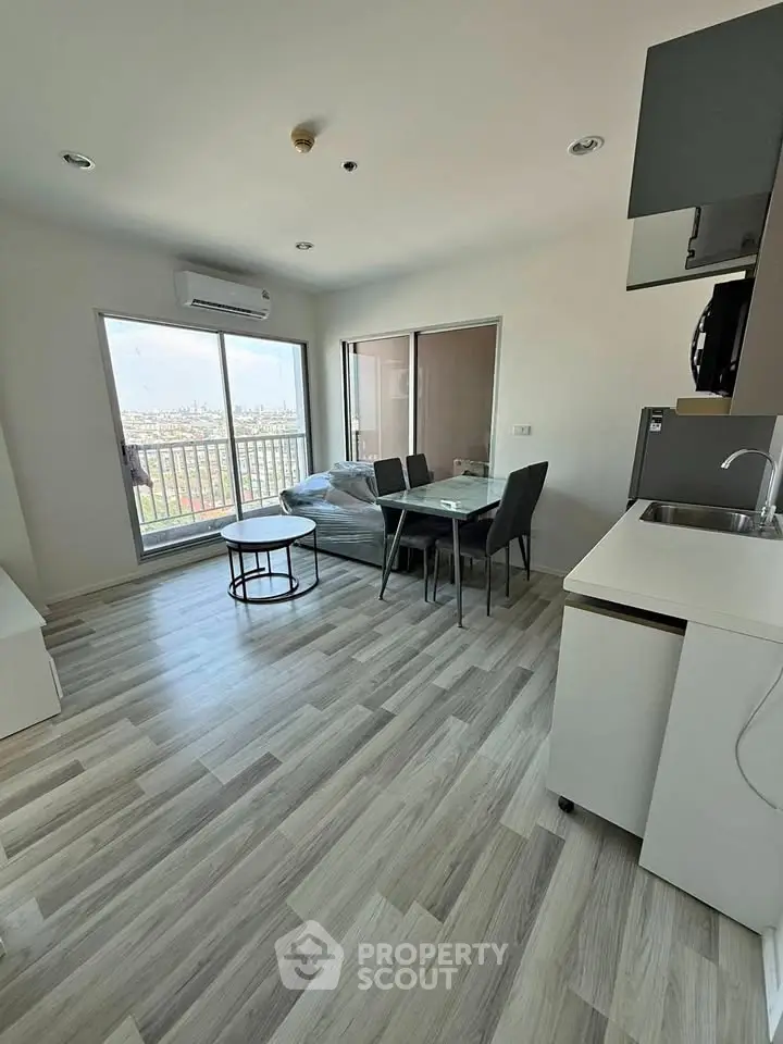 Modern living room with balcony view, sleek furniture, and stylish flooring in a contemporary apartment.